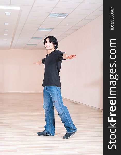 Young cheerful exercise dancer man in training hall. Young cheerful exercise dancer man in training hall