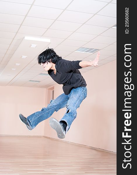 Young dancer man jumping trick in training hall