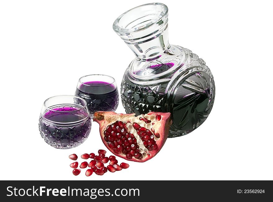 Decanter with garnet juice and pomegranate parts isolated on the white