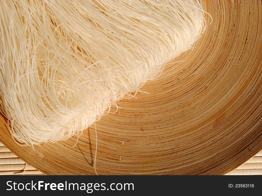 Raw rice noodles on a round wooden dish
