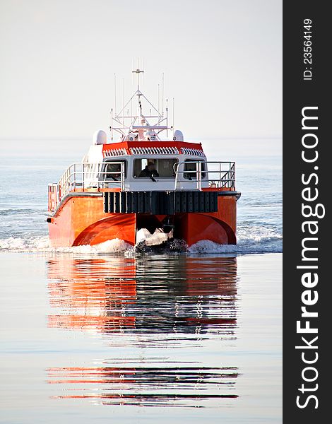 Photo of a bright red or orange sea cat vessel coming in to whitstable harbour. Photo of a bright red or orange sea cat vessel coming in to whitstable harbour.