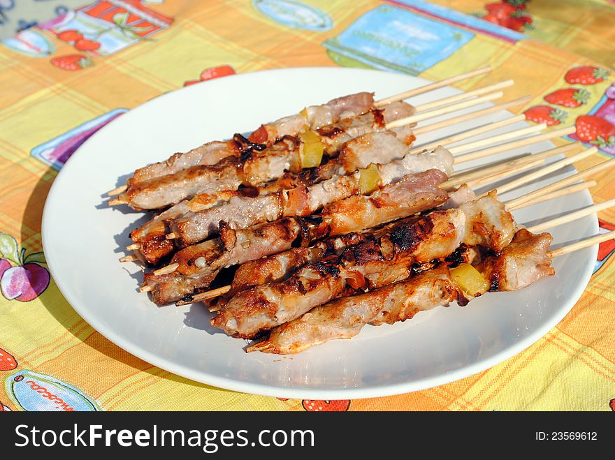 Cocked pork kabobs grilled on skewers in a plate