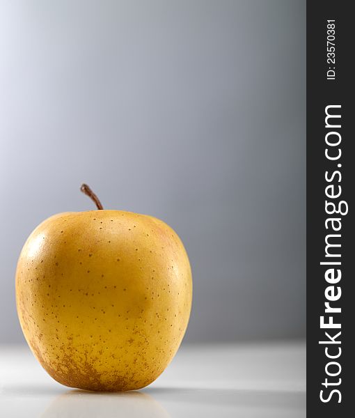 Golden apple over abstract gray backgrounds