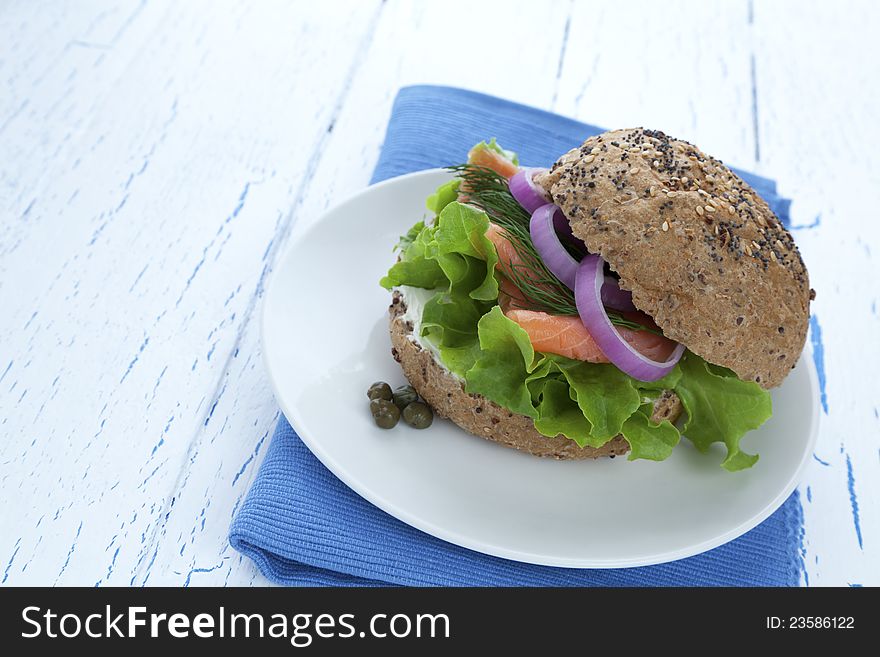 Delicious smoked salmon burger with lettuce, onions, dill and cream cheese