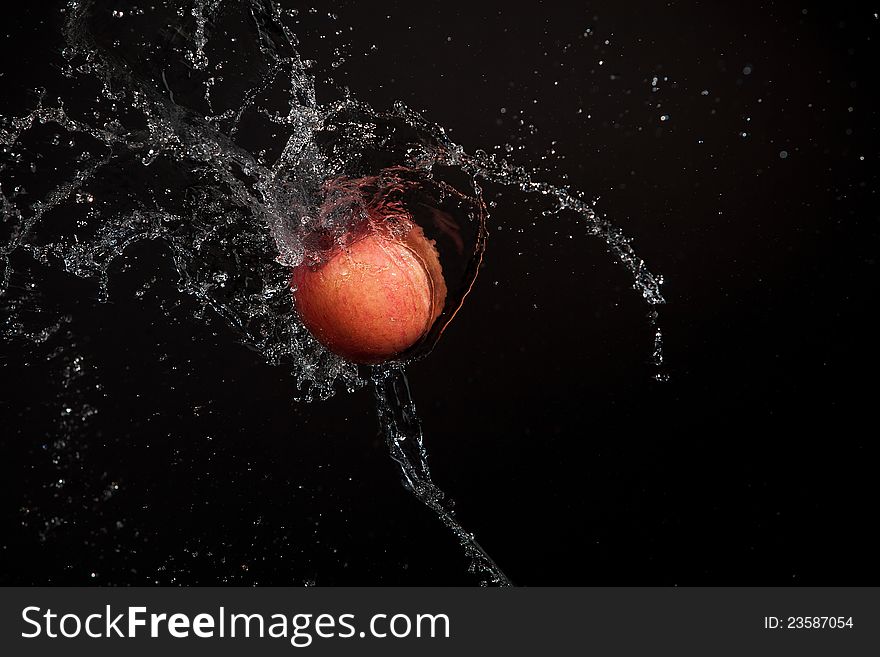 Apple splashed with water on a black background. Apple splashed with water on a black background