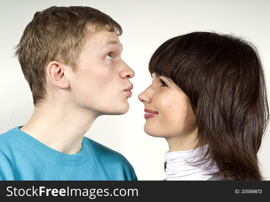 The guy kisses in the nose of a girl, a white background. The guy kisses in the nose of a girl, a white background