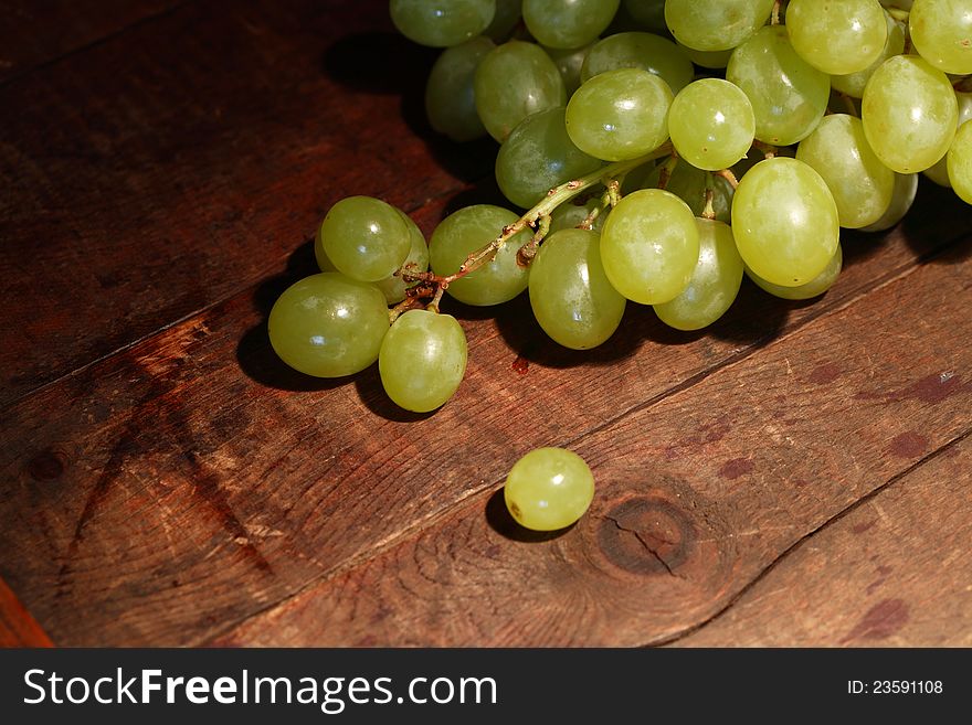 Bunch of green grapes on wooden background with free space for text. Bunch of green grapes on wooden background with free space for text