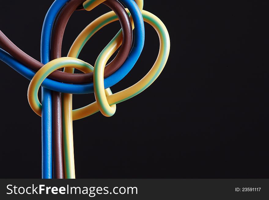 Abstract composition with knotted colored wire on dark background