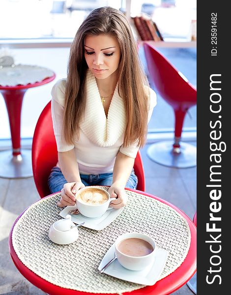 Young Woman Sitting In The Cafe With A Cup Of Tea