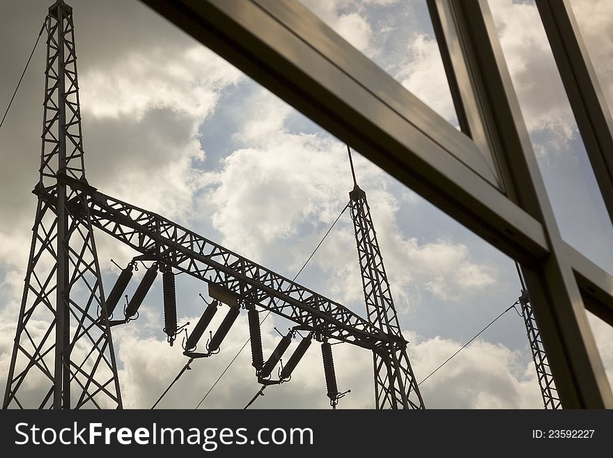 Reflection of power pylons in glasses of a building