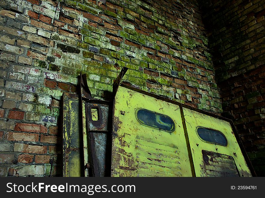 Old steel door leaning against a brick wall cracked. Old steel door leaning against a brick wall cracked