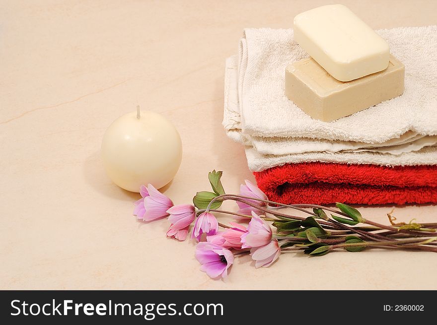 Red and white towels and honey soaps with candle in spa bathroom (spa concept )