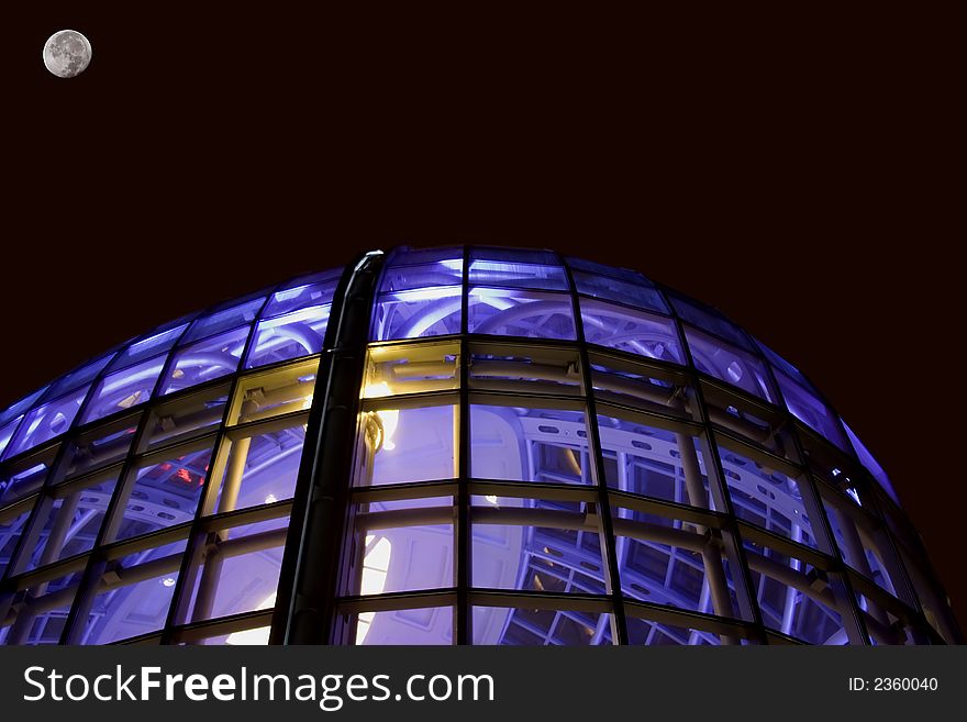 Night shot of glass office building window glass lit with blue purple light room for type above building. Night shot of glass office building window glass lit with blue purple light room for type above building