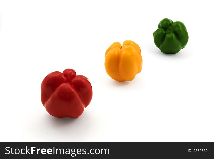 Red yellow and green bell peppers isolated on white