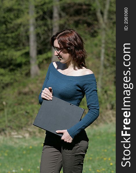 Beauty woman work with notebook in a grass. Beauty woman work with notebook in a grass