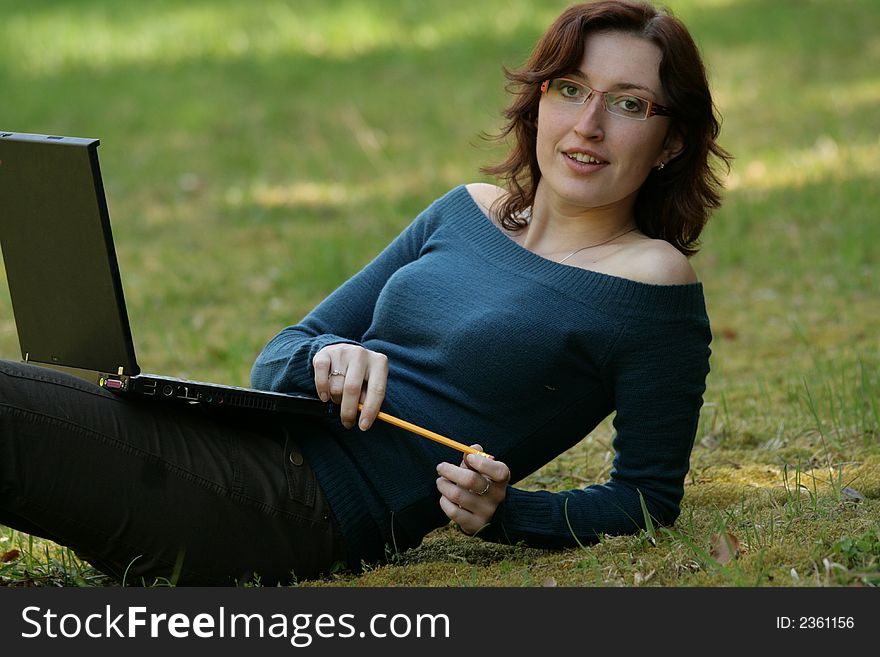 Beauty woman work with notebook in a grass. Beauty woman work with notebook in a grass