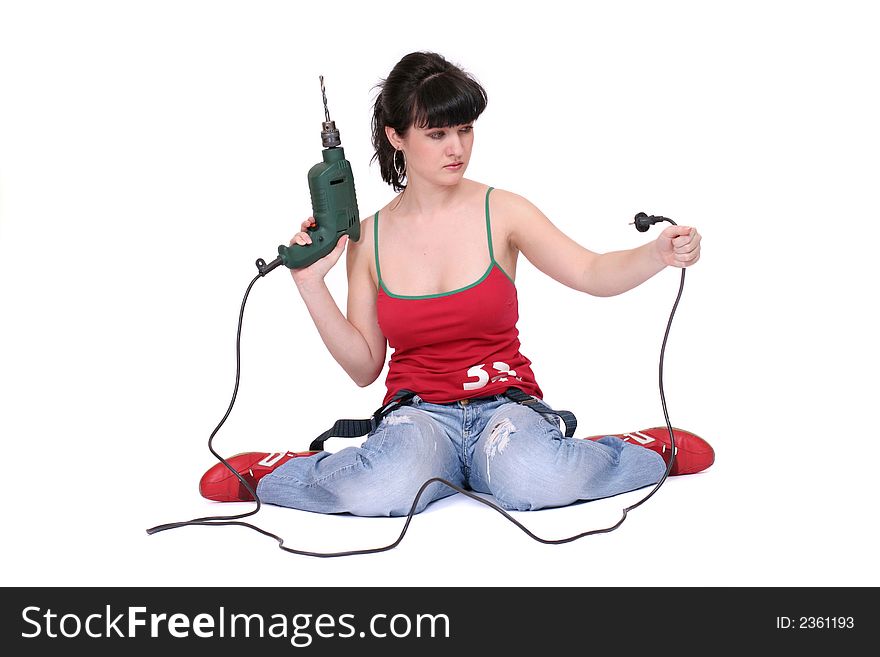 A woman sits and looks at a drill's flex with incomprehension. White background. A woman sits and looks at a drill's flex with incomprehension. White background