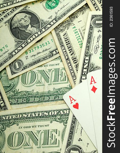 Many available dollars and playing cards on  background of paper banknotes. Many available dollars and playing cards on  background of paper banknotes