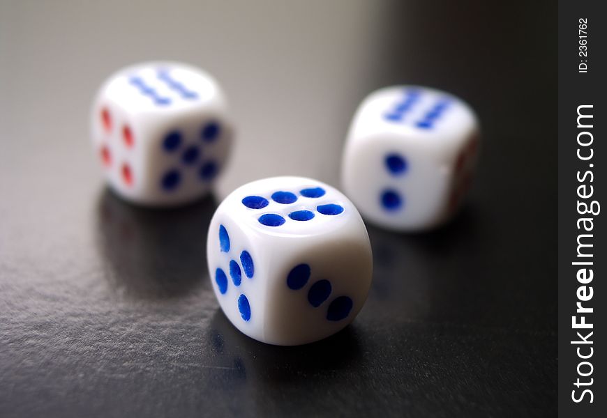 Three white dices on black reflect background. Three white dices on black reflect background
