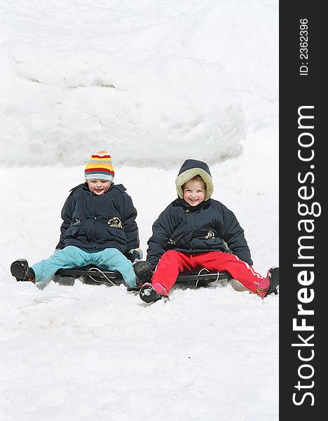 Sisters twins on sledge in the winter. Sisters twins on sledge in the winter