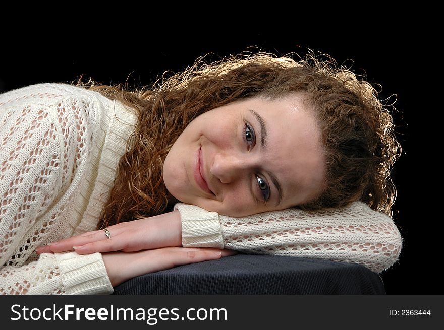 Teen girl reclyning on her hands against a black background. Teen girl reclyning on her hands against a black background