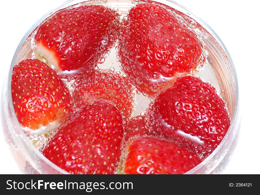 Red strawberries into glass of champaign