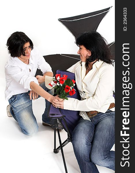 Teen offering his mom flowers over white background. Teen offering his mom flowers over white background