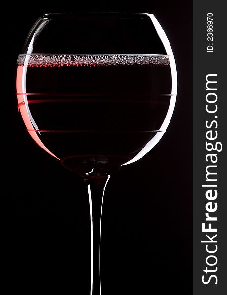 Portrait orientation of a glass of red wine with a black background. Portrait orientation of a glass of red wine with a black background.