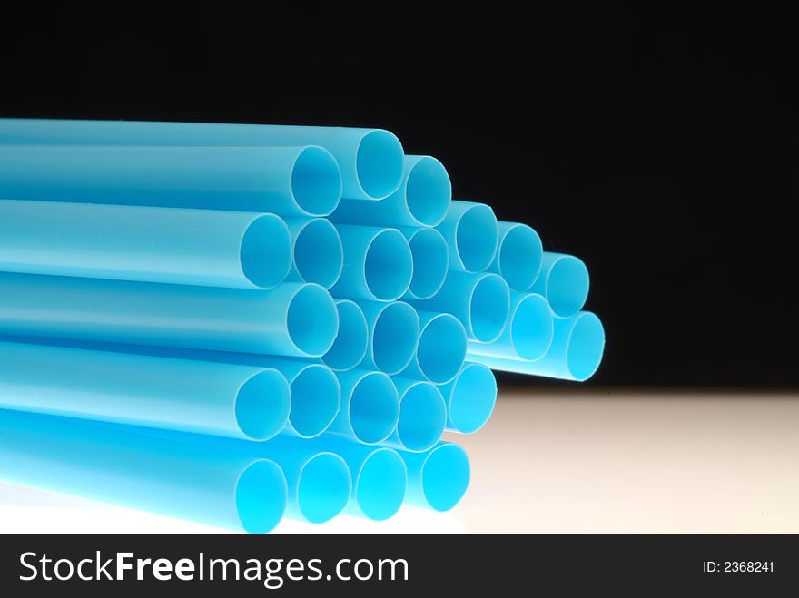 Blue straw against black background