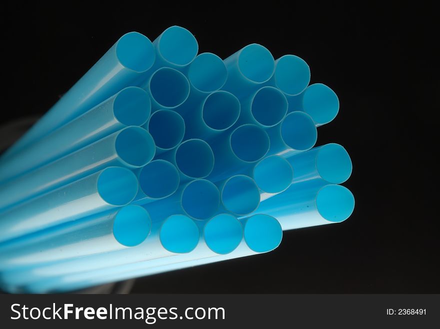 Blue drink straw against black background