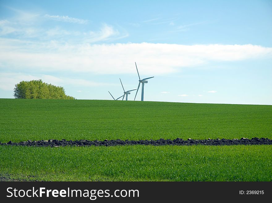 Wind dynamo, green grass and blue sky