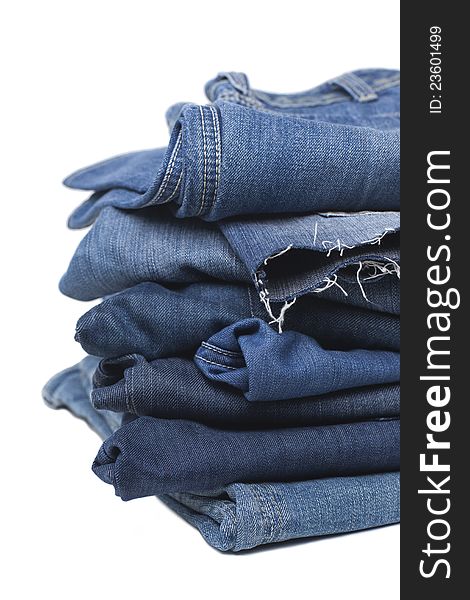 Stack of Blue Jeans isolated on white with drop shadow, copy space