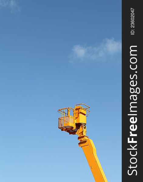 Cherry picker platform against a blue sky