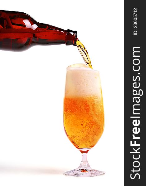 Beer pouring from bottle into glass on white background