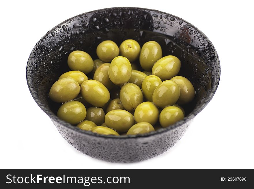 Some green olives in a bowl on white. Some green olives in a bowl on white