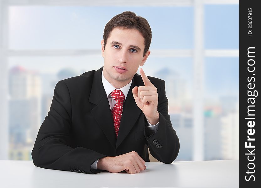 Successful businessman seriously sitting at desk