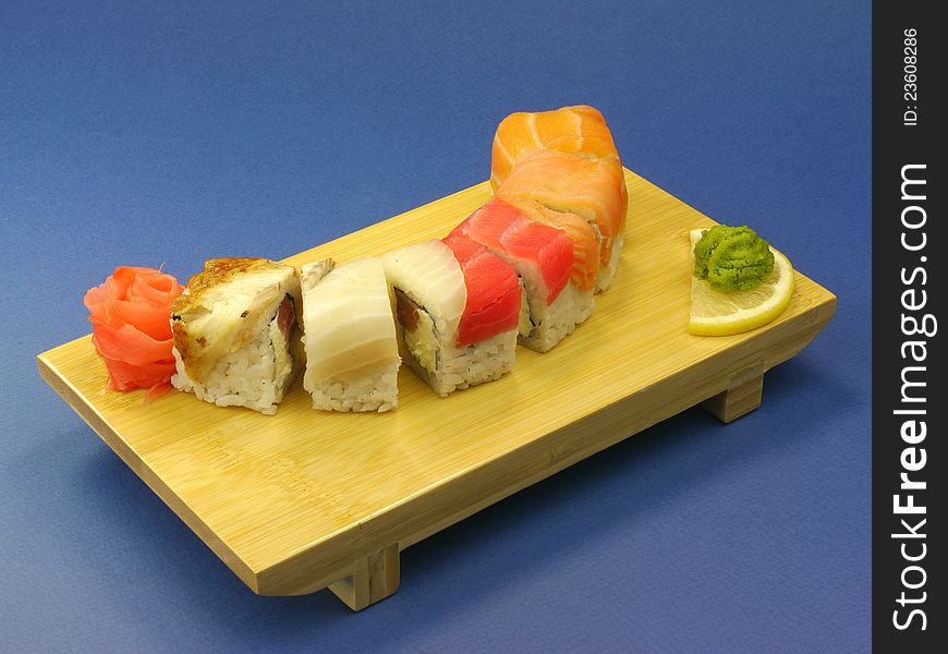 Delicious sushi with salmon and eel on wooden plate.