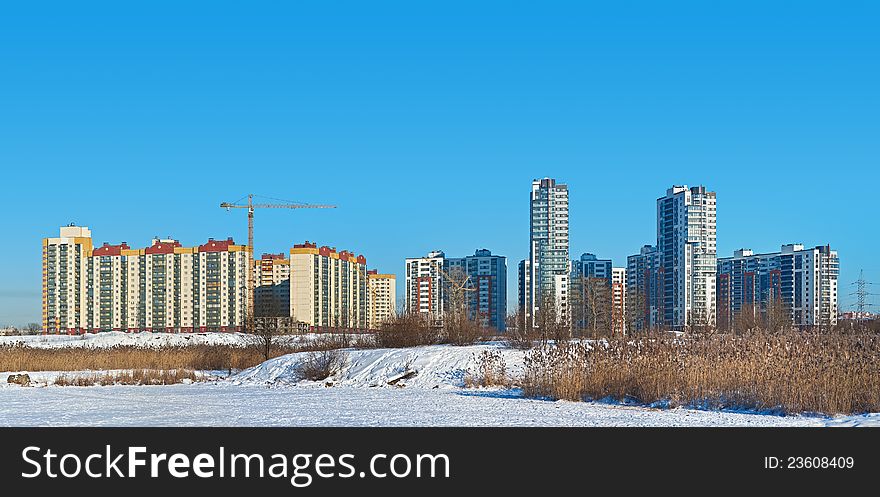 Frozen lake with views of the construction of apartment complex