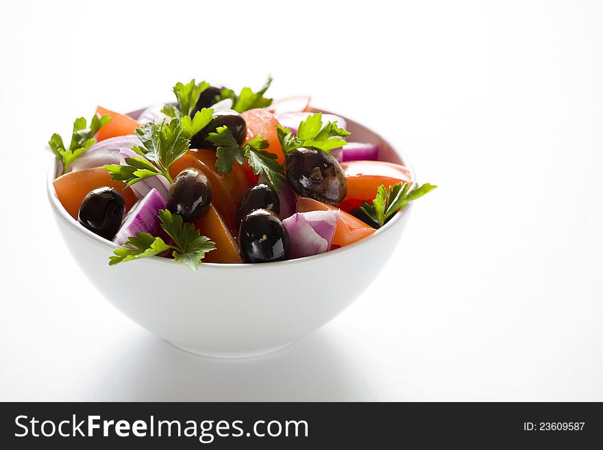 Photograph of a bowl of greek salad  on white