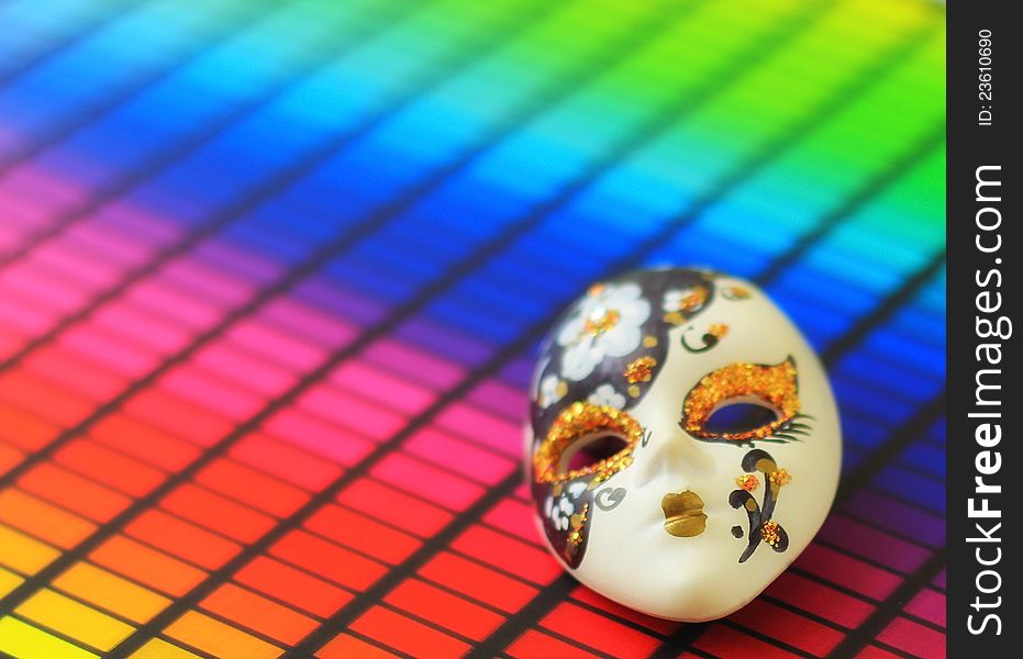 Small venetian mask on rainbow surface. Small venetian mask on rainbow surface.