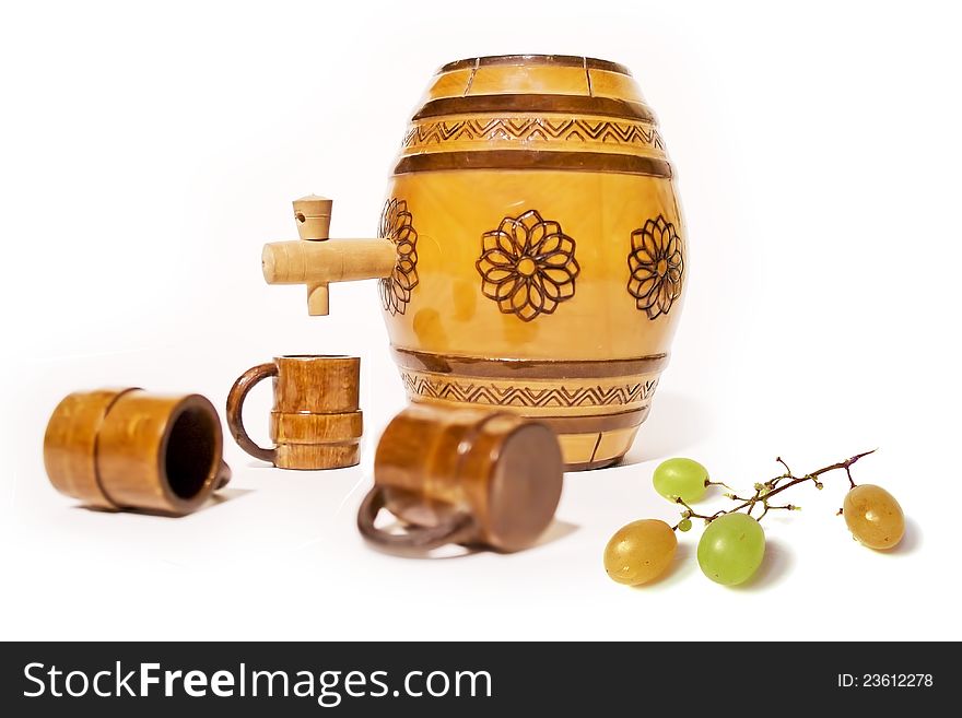 Small decorative wooden barrel with wooden cups and grapes on white background. Small decorative wooden barrel with wooden cups and grapes on white background.