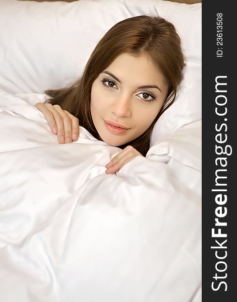 Beautiful brunette woman in bed