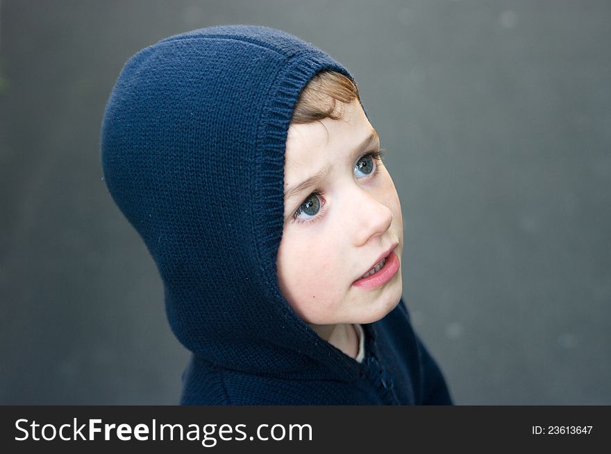 A portrait of a boy in navy blue hood