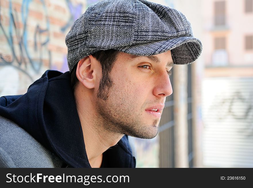 Portrait of handsome man in urban background wearing a retro cap. Portrait of handsome man in urban background wearing a retro cap