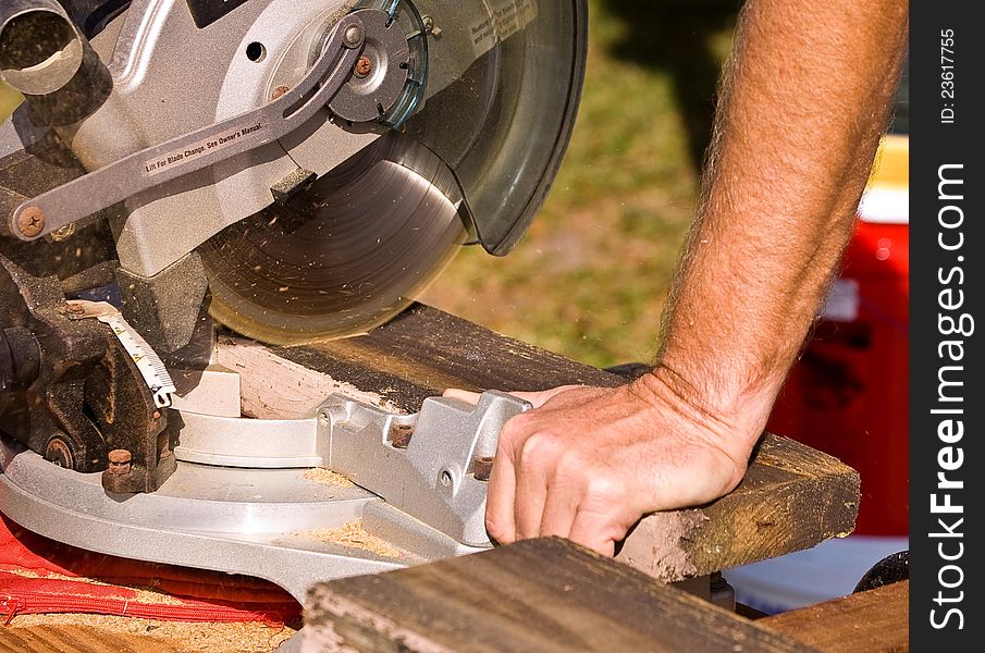 Using a miter saw to cut wood.