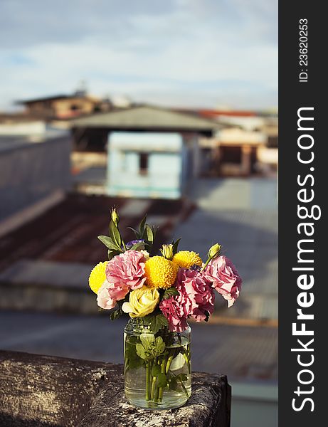 Bunch of flowers in a glass jar outside