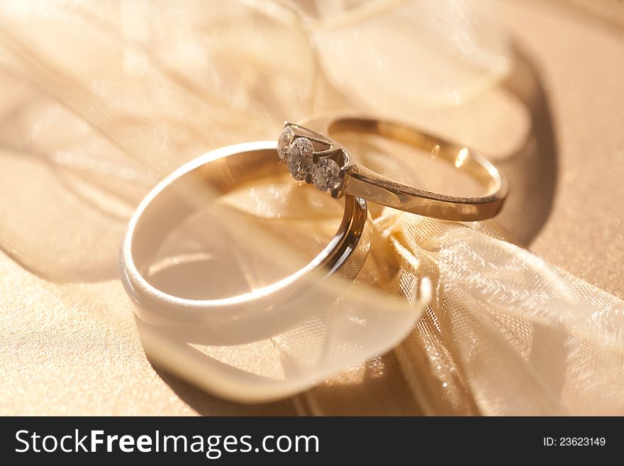 Two gold wedding rings with diamond with tender ribbon around. Two gold wedding rings with diamond with tender ribbon around
