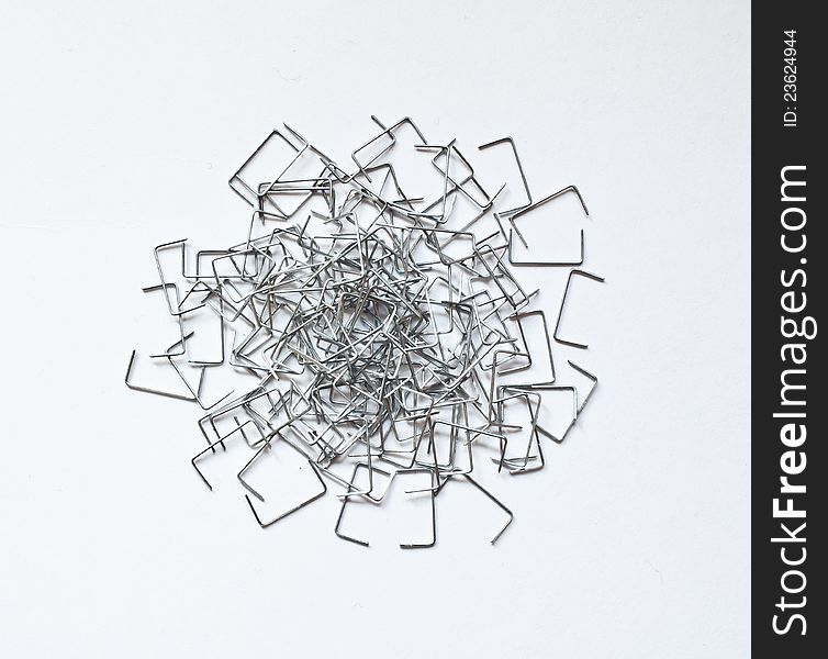 Staples scattered on a white surface. Staples scattered on a white surface