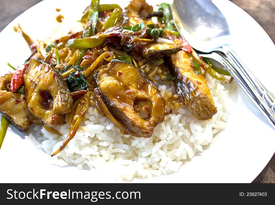 Fried fish topped with spicy rice.