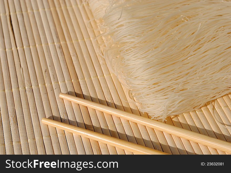 Rice needles on a bamboo place mat with chopsticks